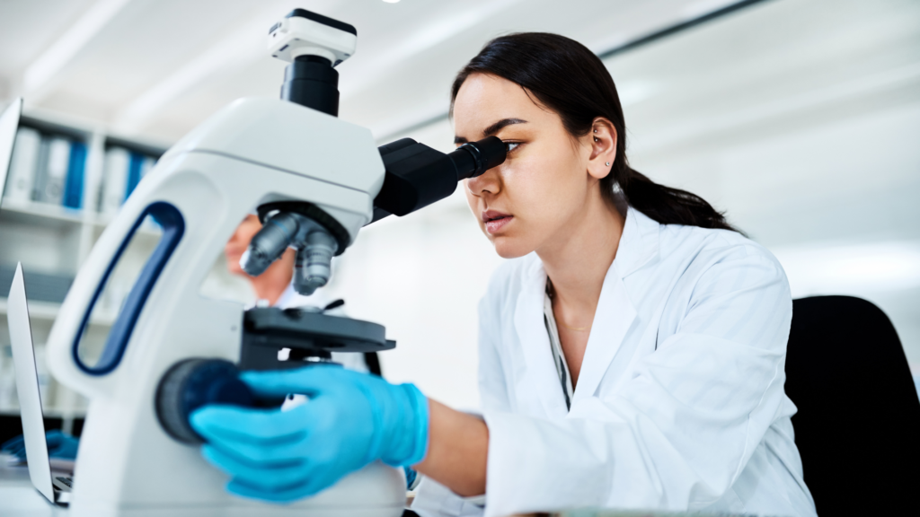 Clinical trials featuring a female medial doctor looking into a micropsope.